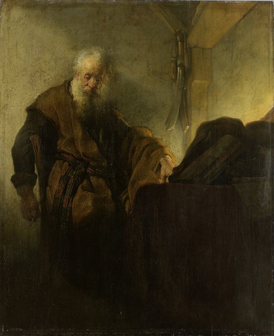 O apóstolo Paulo, já idoso, de pé ao lado de uma mesa com livros, em pintura de Rembrandt