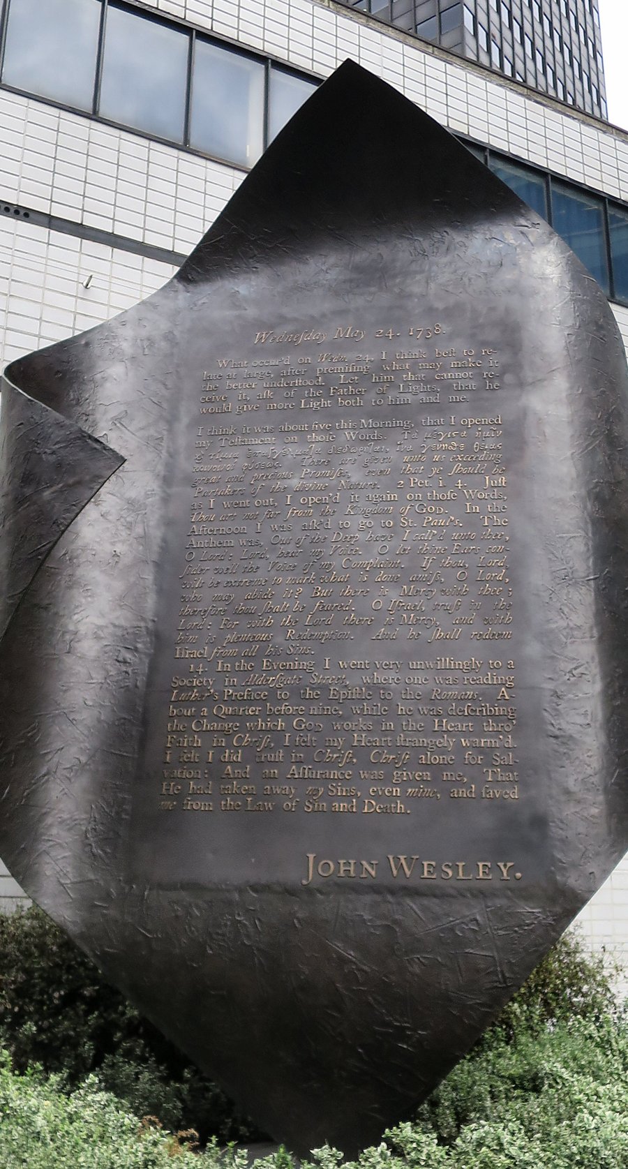 Escultura de bronze em forma de pergaminho enrolado, com o relato de John Wesley sobre a noite de 24 de maio de 1738