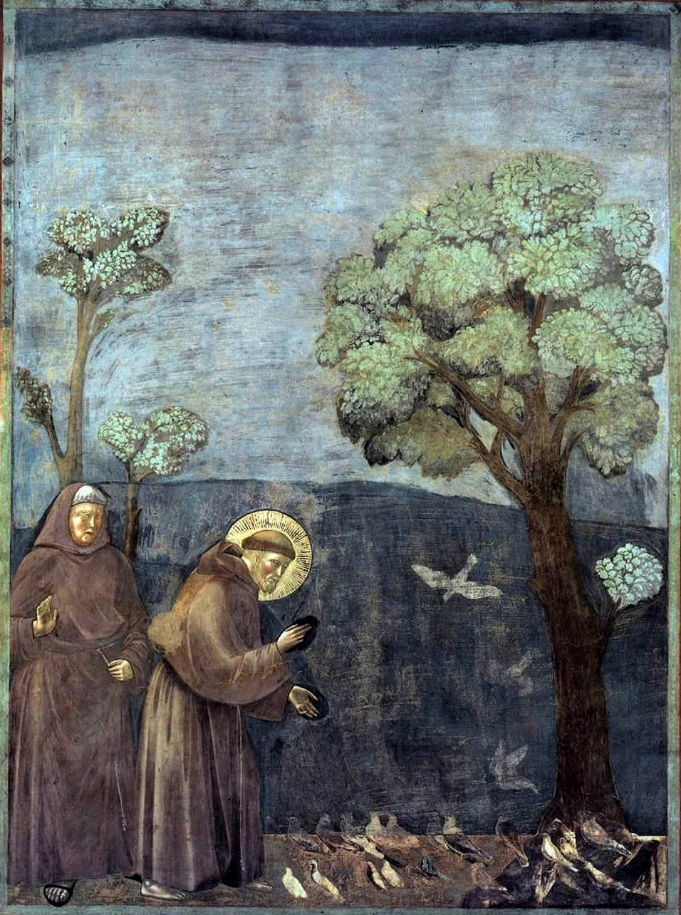 Francisco de Assis, de hábito marrom e auréola, inclina-se para pregar às aves, ao lado de um frade, sob grandes árvores