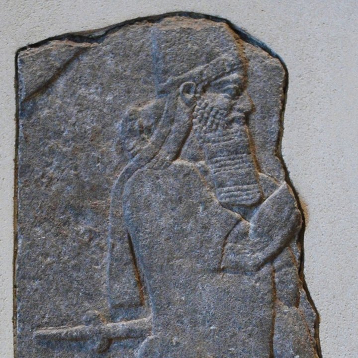 Relevo assírio em alabastro mostrando o rei Tiglate-Pileser III de perfil, com barba e tiara, empunhando um cetro