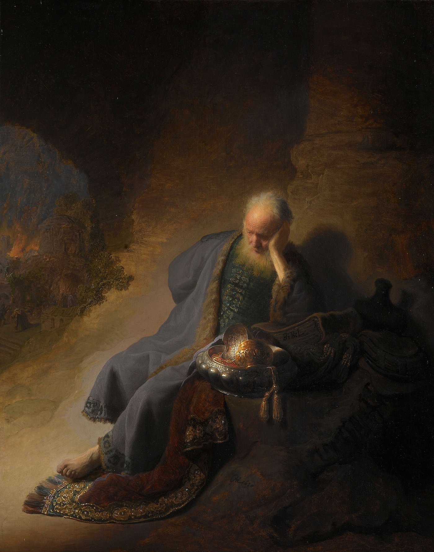 O profeta Jeremias, velho e de barba branca, sentado numa encosta de pedra com a cabeça apoiada na mão, ao lado de objetos de ouro do templo, enquanto Jerusalém pega fogo ao fundo, em pintura de Rembrandt
