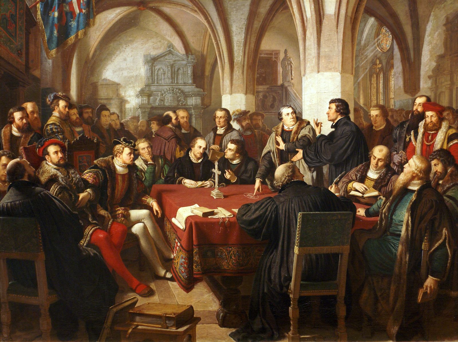 Lutero e Zuínglio discutem à mesa diante dos demais teólogos no Colóquio de Marburg, em 1529
