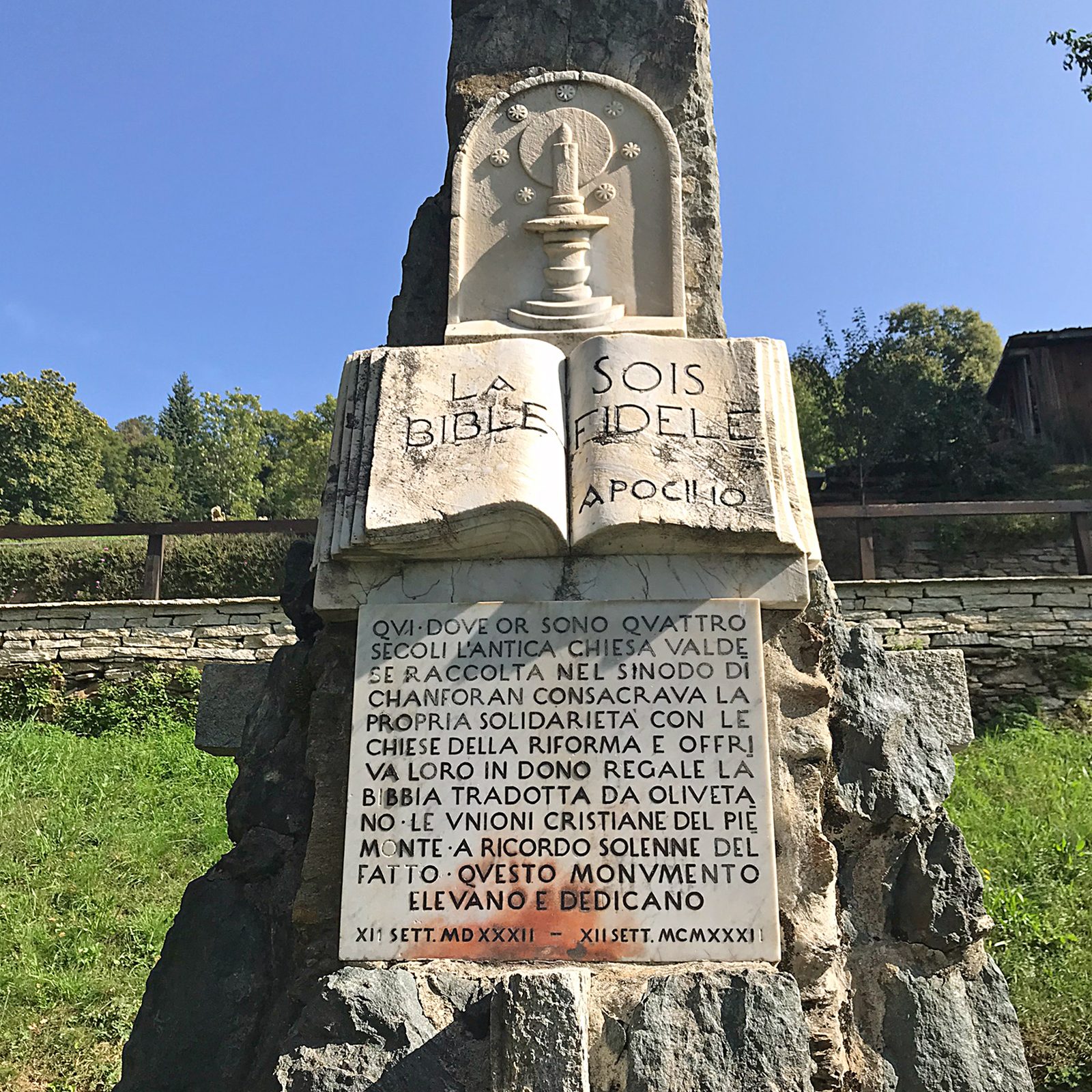 Memorial do Sínodo de Chanforan, em Angrogna, com o emblema valdense: vela acesa sobre uma Bíblia aberta, cercada por estrelas, e a inscrição 'La Bible, sois fidèle'