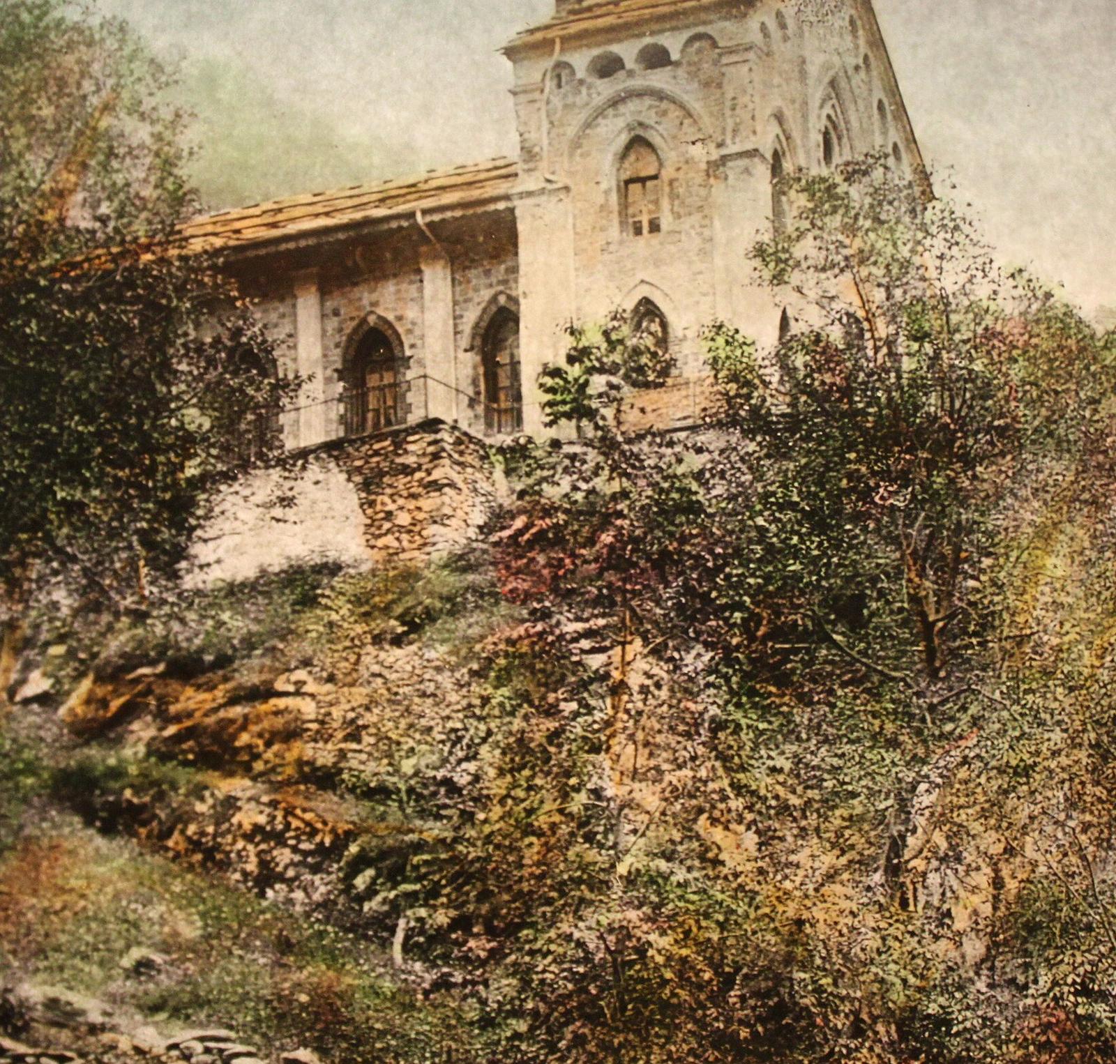 Templo valdense de Pra del Tor, de pedra, sobre uma encosta coberta de vegetação, nos vales alpinos do Piemonte