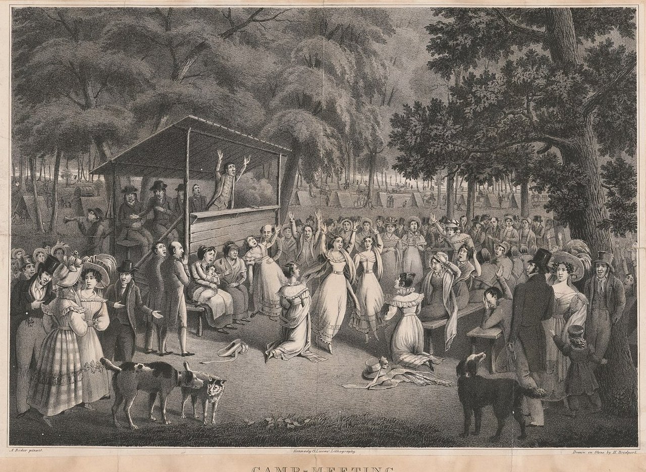 Litografia de um culto metodista ao ar livre, com o pregador de braços erguidos sobre uma plataforma de madeira e fiéis ajoelhados diante dele, entre as árvores